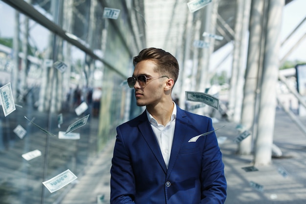 Free Photo | Dollars fly around handsome young businessman while he walks along the street