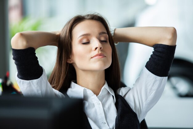 Mujer de negocios alegre soñando en el lugar de trabajo Oficinista toma un descanso después de terminar el trabajo Señora de negocios relajándose en el trabajo | Foto Premium